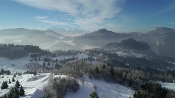 Aerial view of beautiful winter scenery in mountain ski resort. Mountains covered with snow