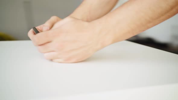 Closeup a Man Uses Smartphone with a Green Screen While Standing at the Table