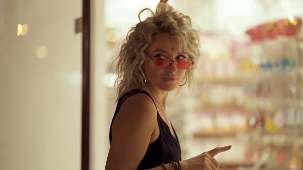 Curly hair woman posing near the window.