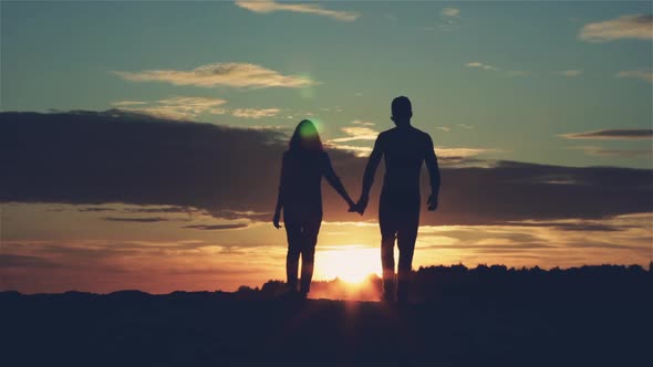 Silhouettes of Loving Man and Women at Sunset
