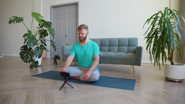 Middleaged Man Picking Up an Online Workout Guide for His Home Workout alt
