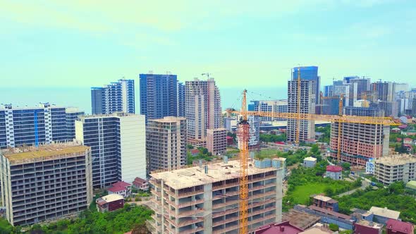 Drone view of a multi-storey building under construction with a tower crane alt