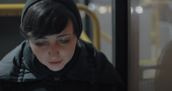 Woman commuter with mobile in the bus alt