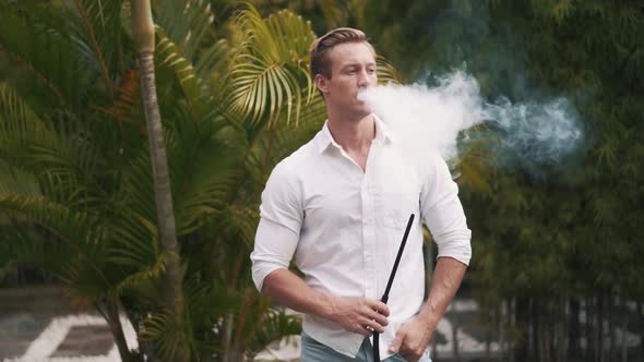 Slowmotion Video of Caucasian Man Smoking Hookah and Relaxing alt