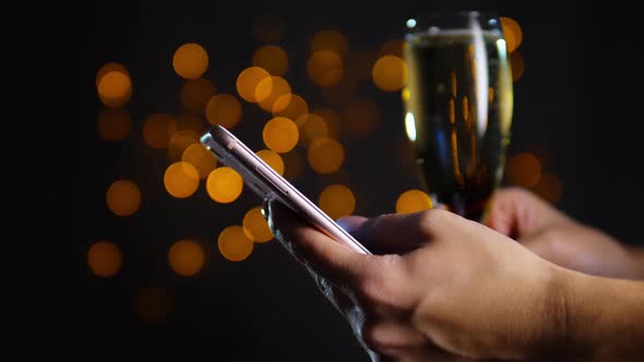 Smartphone in hands on blurred gold background