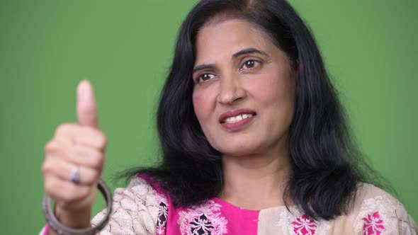 Close Up Shot of Mature Happy Beautiful Indian Woman Smiling While Giving Thumbs Up alt