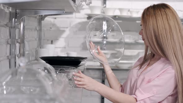 The Woman at the Tableware Shop Is Choosing a Glass Tray with a Cap alt