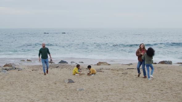 Parents Have Fun with Children On Ocean Coast