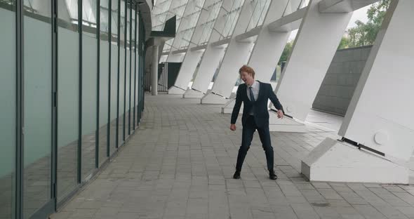 Amazed Businessman Rejoices in Victory Jumps Into the Air and Shows the Yes Gesture alt