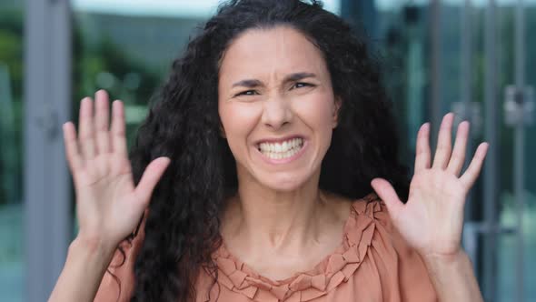 Female Portrait of Young Hispanic Woman with Curly Long Hair Stands Outdoors Shouts Angry Waving alt