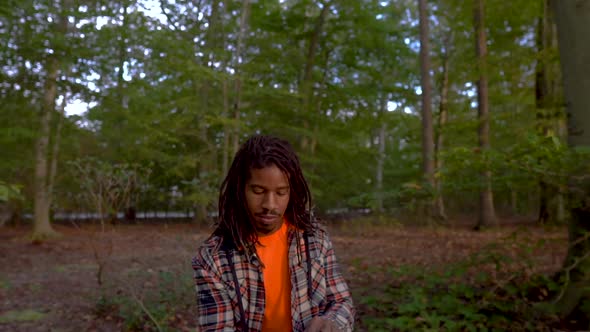 Tilt Down To Man in Park Reading Book By Himself