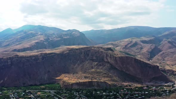Aerial Drone Shot of Armenia Landscape and Houses at the Bottom of the Mountains alt