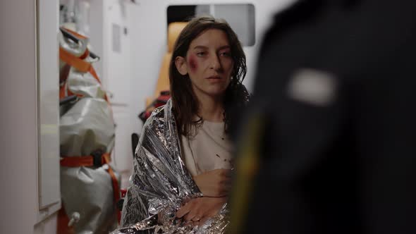 African Paramedic Giving Tea to Injured Woman in Ambulance alt