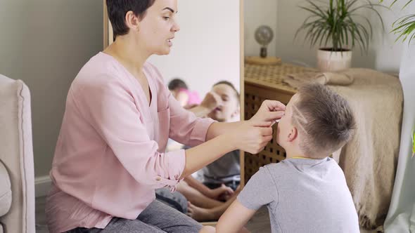 Mother Puts Paper on Little Son Nose at Logopedic Exercise