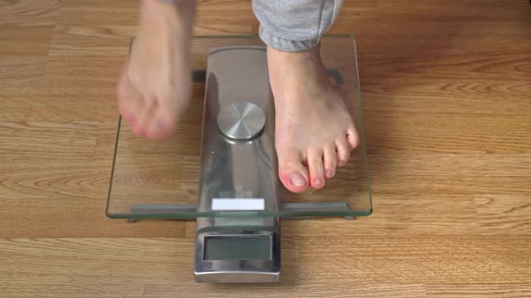 Women's Feet Stand on the Scales and Check Their Kilograms Top View alt