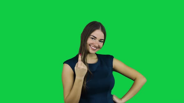 Girl call camera with one finger in front of a green screen alt