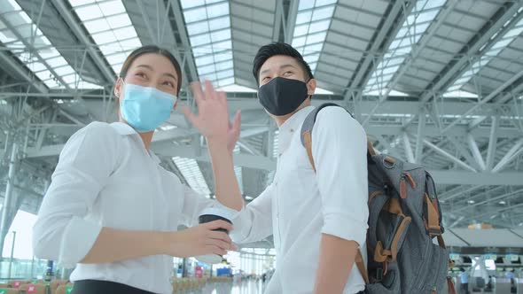 asian businessman and businesswoman wear face mask protection hand gesture wave goodbye