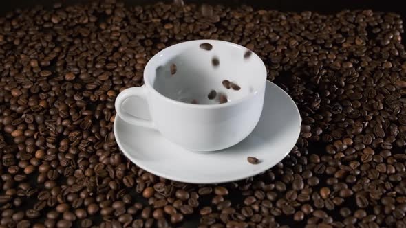 Roasted Coffee Beans Falling Into a White Cup alt
