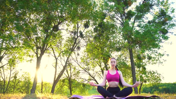 The Girl Is Sitting on the Rug and Do Meditation Under the Sun.