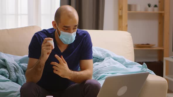 Ill Man at Home Talking Online with His Doctor alt