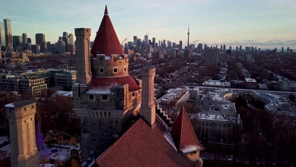 Drone Reveal - Toronto Skyline behind Casa Loma Tower at Winter Sunset. Establishing Wide Shot of Do alt