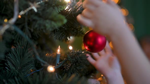 Child decorating a Christmas tree alt