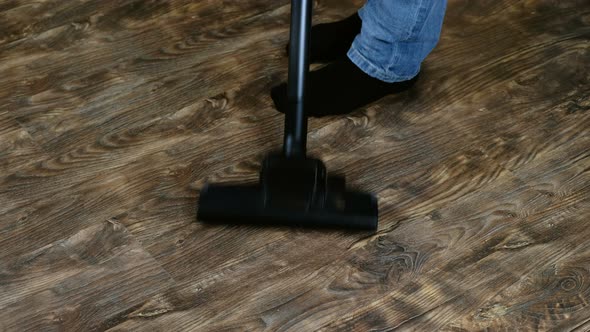 Man Doing Home Cleaning To Vacuum Vacuum Cleaner Floor Laminate To Frame the Feet in Socks 