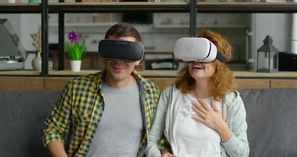 Couple Is Impressed with Virtual Reality Video, Sitting on Sofa, Close Up alt