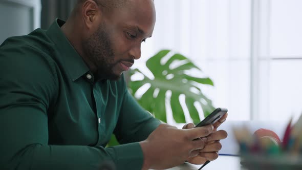 African American man sitting lonely using a smartphone
