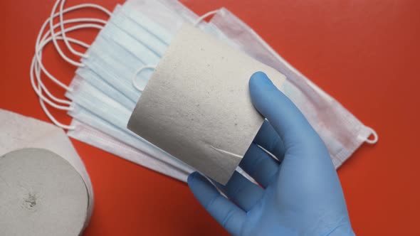 Doctor Showing Rolls Toilet Paper on Background Respiratory Face Masks and Red Color Backdrop