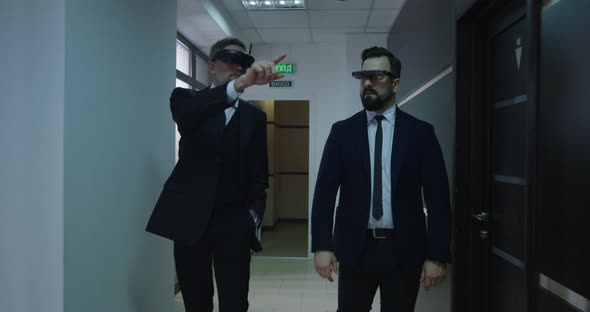 Businessmen Using VR Glasses in Office Corridor alt