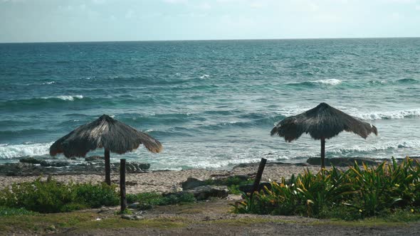 View of the Breaking Waves and Tropical Umbrellas in Isla Mujeres Mexico