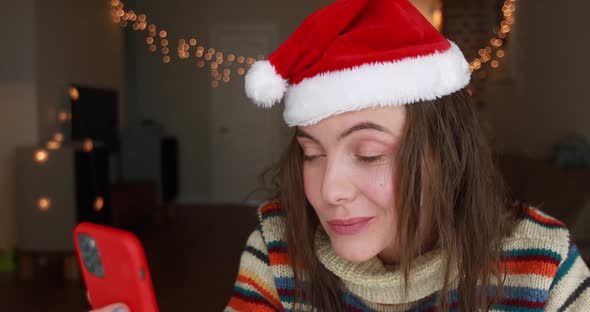 Festive Lady Talks on Video Call Holding Smartphone Closeup alt
