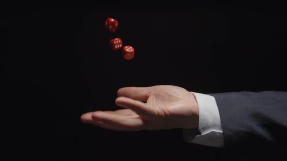 Businessman hand throws up several red playing cubes