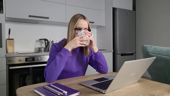 Pensive Young Adult Woman in Glasses Work Study at Kitchen Using Laptop alt