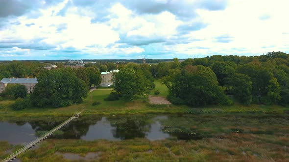 Mezotne Palace and Park With Fountain in Latvia. Lielupe River With Ponton Bridge Aerial 4K alt