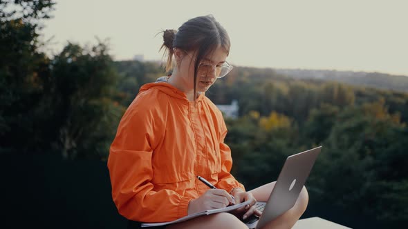 The Young Worker Writes Down Her Todo List to Achieve This Month's Goals in the Middle of Nature alt