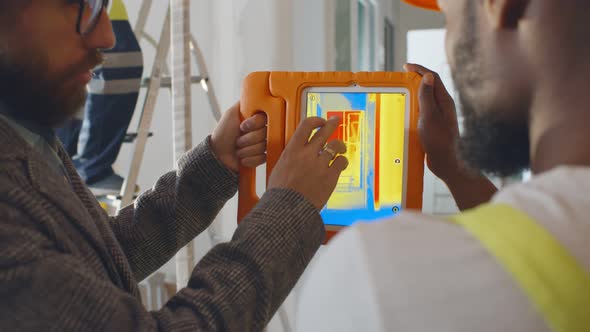 Back View of Professional Construction Team Using Infrared Camera on Tablet Checking Heating System alt