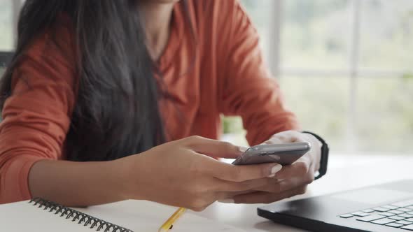 Close up hands Asian businesswoman using smartphone chatting, texting.