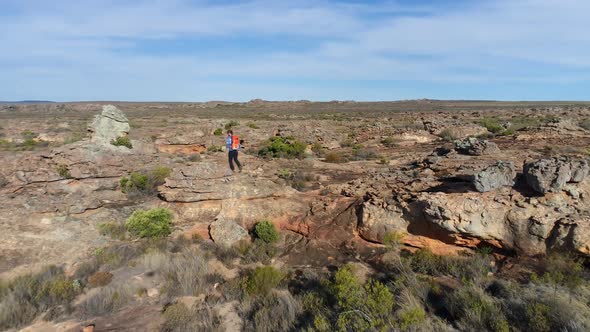 Male rock climber walking over a rocky mountain 4k alt