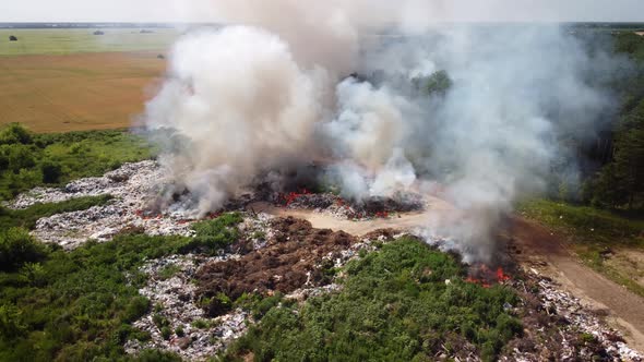 Air pollution by burning garbage at dump site aerial view