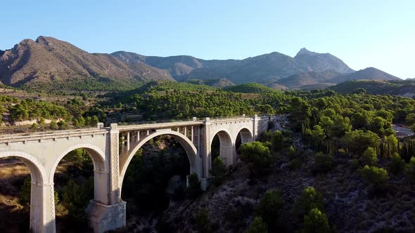 Aerial approach of an old bridge arch alt