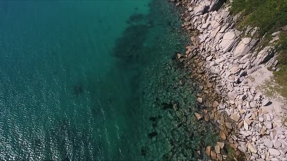 Aerial Shot of Mountain Cliff and Blue Sea Water alt