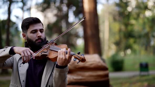 Portrait of a Stylish Male Musician with a Violin Performing a Composition in the Morning in the alt