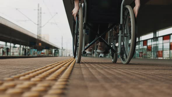 Low Angle, Young Woman Spinning the Wheels of the Wheelchair on the Train Station alt