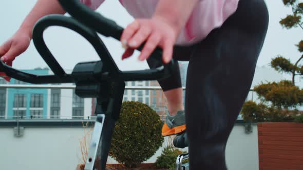 Woman Performs Aerobic Endurance Training Workout Cardio Routine on the Simulators Cycle Training alt