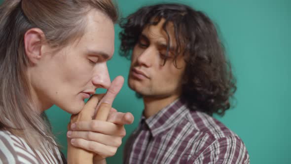 Close Up of Young Gay Couple Embracing and Dancing Isolated on Green Background alt