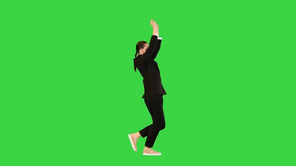 Young Woman in Office Suit Walks Dancing Raising Her Arms on a Green Screen Chroma Key alt