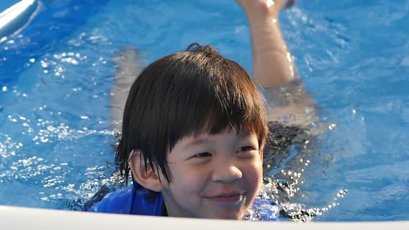 Cute Asian Boy Swimming And Playing In A Pool Slow Motion alt