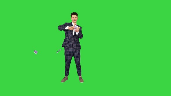 Wealthy Businessman Throwing Money in Air on a Green Screen, Chroma Key. alt